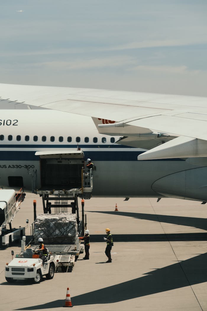 Airbus A330 being loaded with cargo on an airport runway, showcasing transportation logistics.