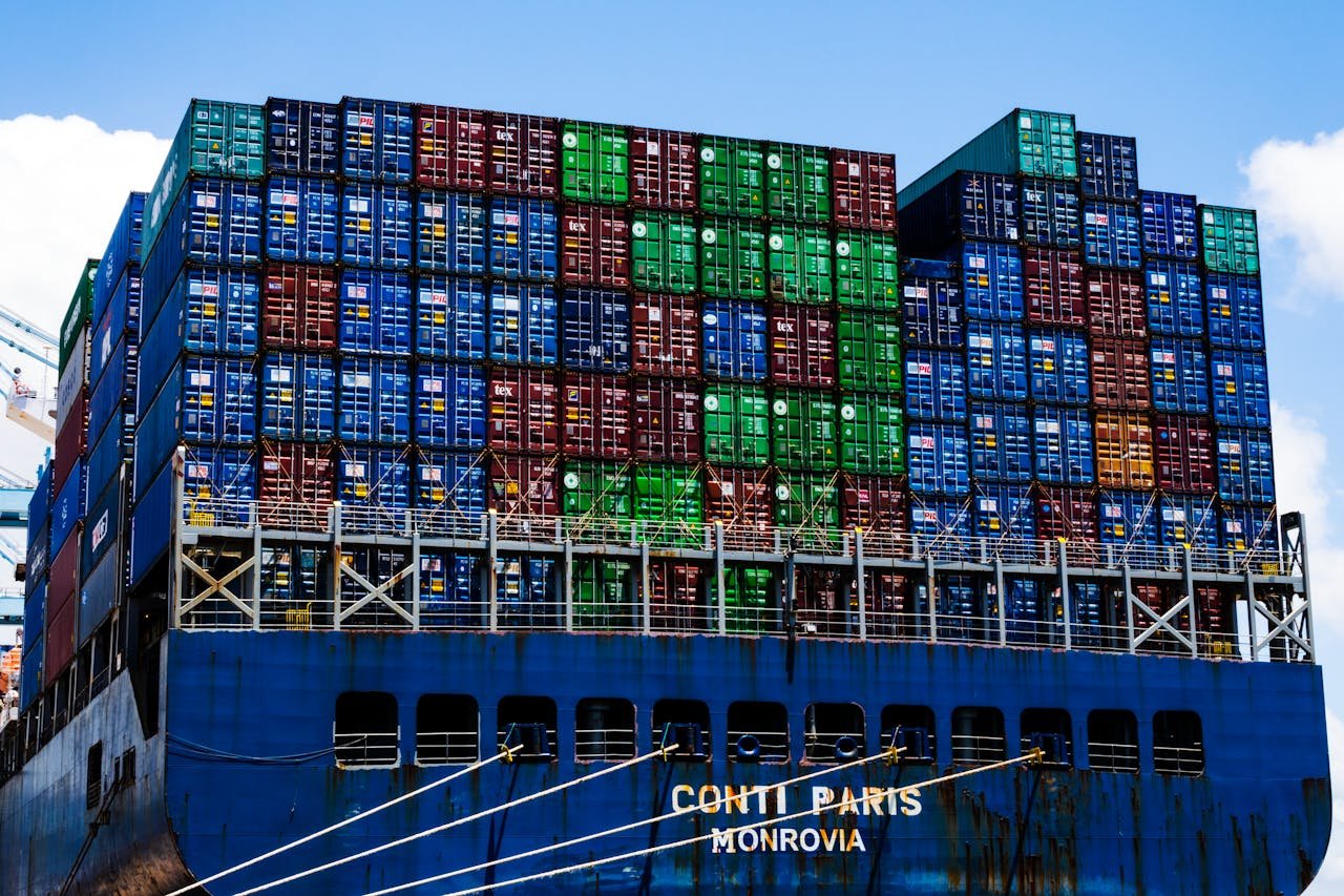 Stacked cargo containers on a massive ship at the harbor, symbolizing global trade.